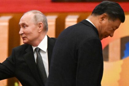 The United States says that China under President Xi Jinping (R) is helping Russia, led by