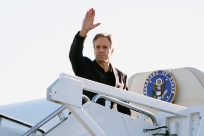 US Secretary of State Antony Blinken waves as he boards his plane at Joint Base Andrews on