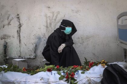 A woman mourns by a body unearthed at Nasser Hospital in Khan Yunis
