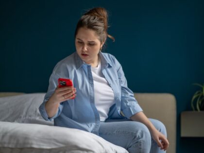 woman looking at cell phone at home