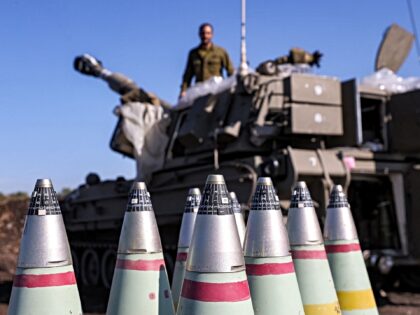 The tips of 155mm artillery shells are pictured near a self-propelled howitzer deployed at
