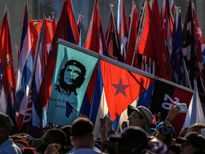 Cubans file past waving national flags and flags with the image of revolution hero Ernesto