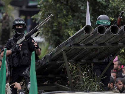 Palestinian Hamas masked gunmen display their military skills during a rally to commemorat