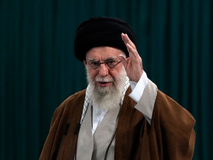 Iranian Supreme Leader Ayatollah Ali Khamenei waves to media after he voted for the parlia