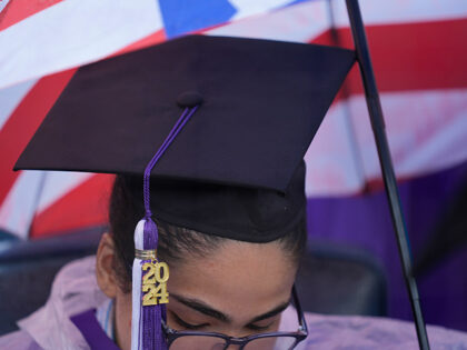 A New York University graduate sits in the rain before the start of the commencement cerem