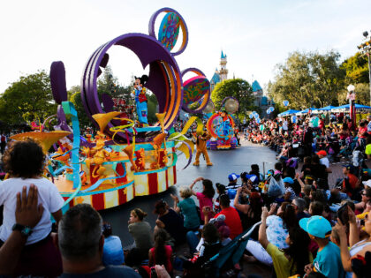 Crowds of guests gather to watch Mickey Mouse in "Mickey's Soundsational Parade&