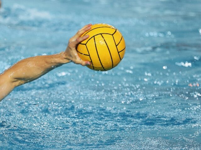 Yellow Water Polo Ball falling into the water with huge splashing effect around, natural l