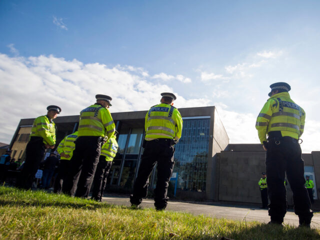 Police outside Kirklees Magistrates Court, West Yorkshire, where seventeen men and a woman