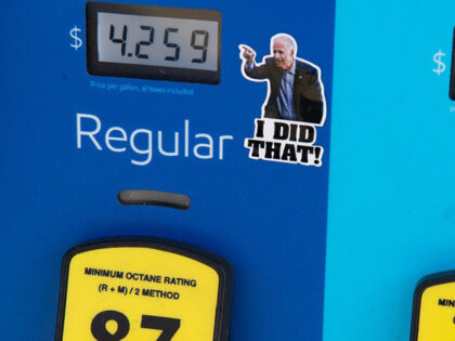 A gas pump displays current fuel prices, along with a sticker of US President Joe Biden, a