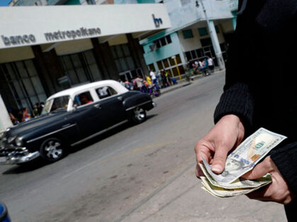 A person shows US dollars outside a bank in Havana, on April 11, 2023, a day after the Cub