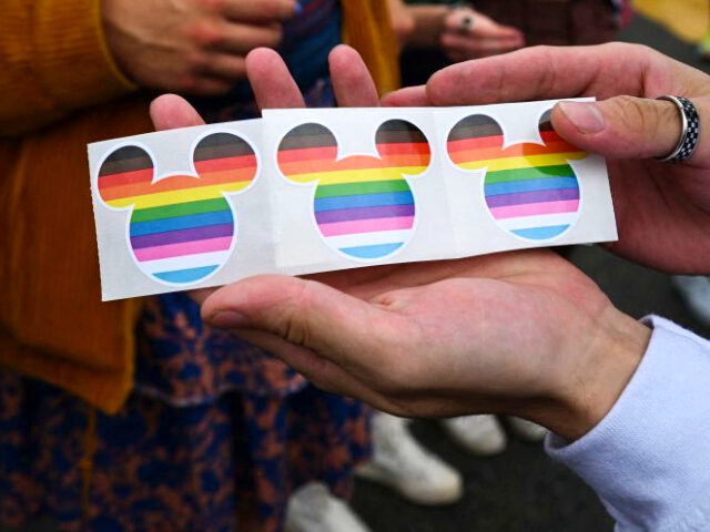 Disney Mickey Mouse ears stickers in rainbow colors are offered to spectators by the Disne
