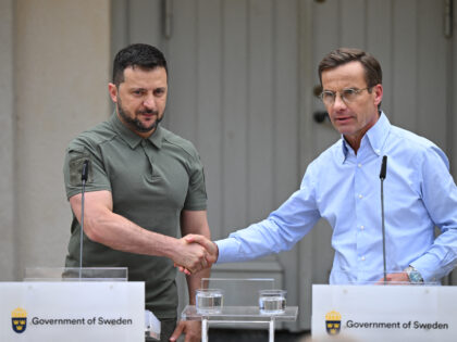 Ukrainian President Volodymyr Zelensky (L) and Swedish Prime Minister Ulf Kristersson shak