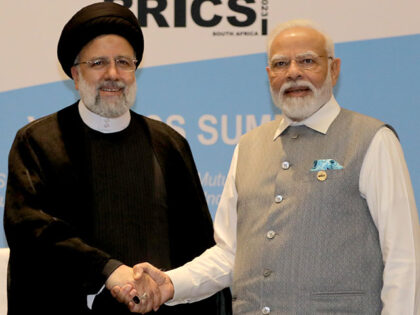 Iranian President Ebrahim Raisi (L) meets with Indian Prime Minister Narendra Modi (R) as