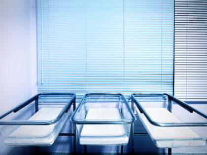 Baby cribs at a maternity ward. Low birth rate and fertility concept.