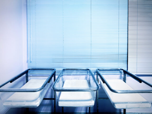 Baby cribs at a maternity ward. Low birth rate and fertility concept.