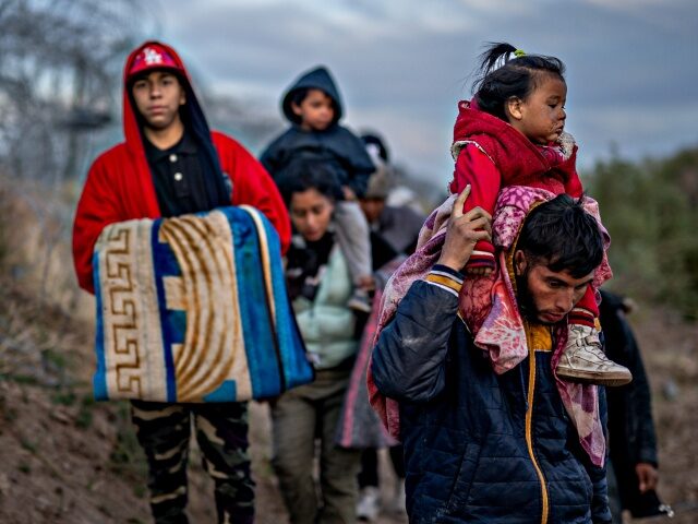EL PASO, TEXAS - MARCH 26: Peruvian migrant Jordan and his 1-year-old daughter Briana lead