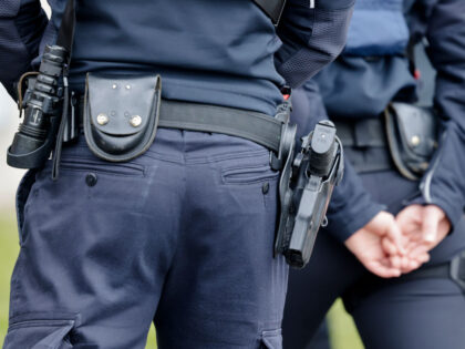 24 April 2024, Schleswig-Holstein, Kiel: Two police officers carry service weapons on a be