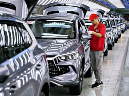 A worker checks the quality of a new energy vehicle NEV at the plant of BYD, China's