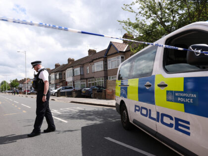 TOPSHOT - A police officer stands on duty at a cordon of a crime scene in Hainault, east o