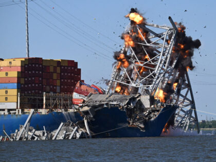 A planned explosion cuts apart a section of steel truss from the Francis Scott Key Bridge