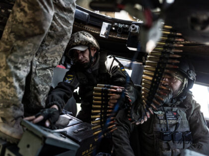 DONETSK OBLAST, UKRAINE - MAY 14: Ukrainian soldiers load the machine gun of a hammer duri