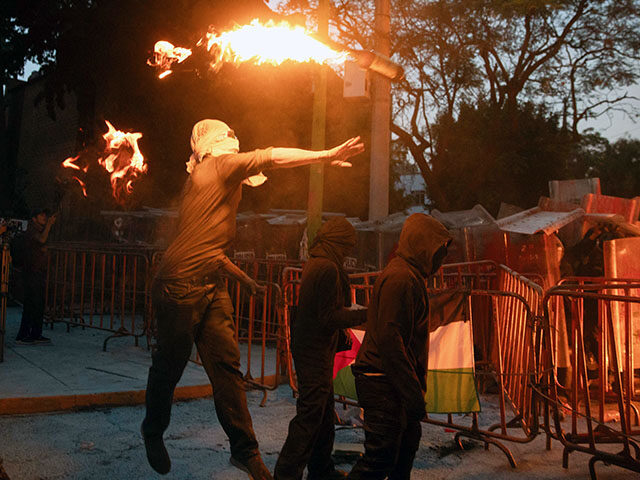 A man throws a molotov cocktail as demonstrators clash with riot police, during a pro-Pale