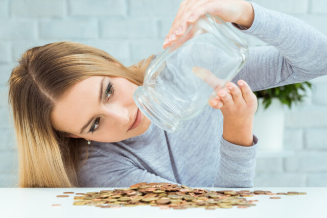 Beautiful woman with money jar. Bankruptcy concept.