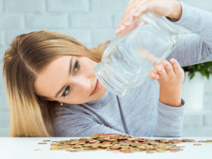 Beautiful woman with money jar. Bankruptcy concept.