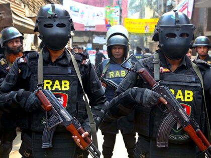 Members of Rapid Action Battalion (RAB) stand guard outside the militant hideout on Januar
