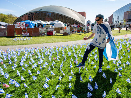 A pro-Israeli supporter plants US and Israeli flags outside the pro-Palestinian encampment