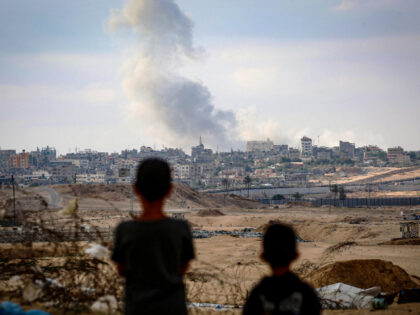 TOPSHOT - Boys watch smoke billowing during Israeli strikes east …