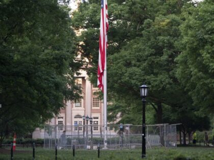 The American flag is surrounded by a temporary barrier at Polk Place at the University of