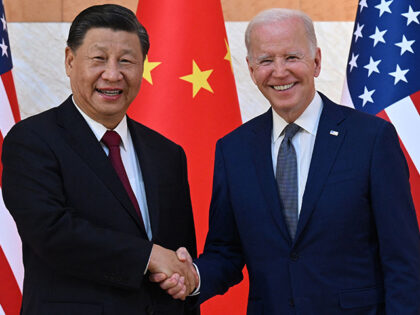 US President Joe Biden (R) and China's President Xi Jinping (L) shake hands as they m