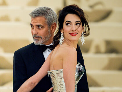 Actor George Clooney (L) and lawyer Amal Clooney enter the Heavenly Bodies: Fashion &
