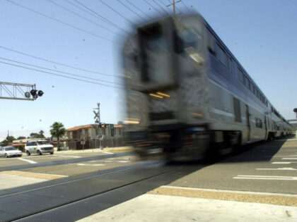 A high-speed Amtrak train roars through a railroad crossing in the Old Town tourist distri