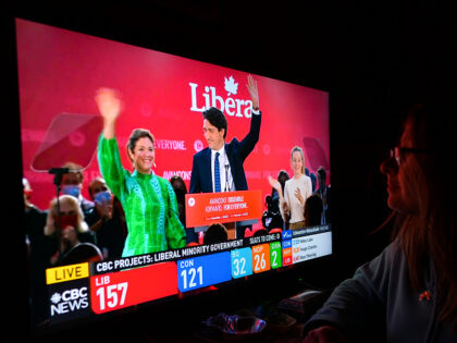 A woman watches Liberal Party of Canada Leader Justin Trudeau celebrating with his family
