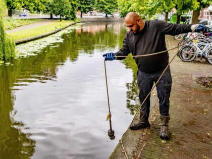 Magnetic fisherman Glenn van den Brekel searches the bottom of a canal in The Hague, The N
