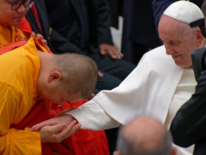 Pope Francis greets a Buddhist monk as he leaves after the weekly general audience in the