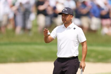 American Xander Schauffele reacts after sinking his final putt for a nine-under 62 that ma