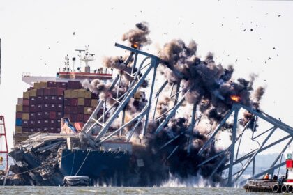 Crews conduct a controlled demolition of a section of the Francis Scott Key Bridge, restin