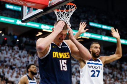 Denver's Nikola Jokic, left, reacts after being fouled by Minnesota's Rudy Gobert, right,
