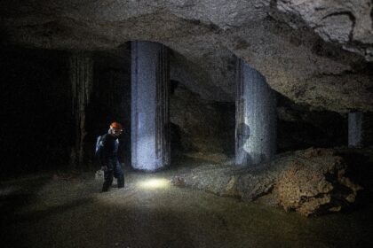 Environmental activist Roberto Rojo stands next to metal columns inside a cave supporting