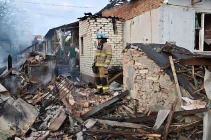 Firefighters clear debris from private houses in the suburbs of Kharkiv