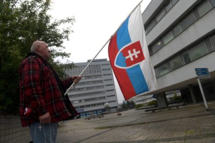A government supporter holds a Slovakian flag outside the hospital treating Fico with the