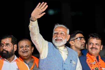 India's Prime Minister Narendra Modi waves to a crowd in Mumbai on May 15, 2024