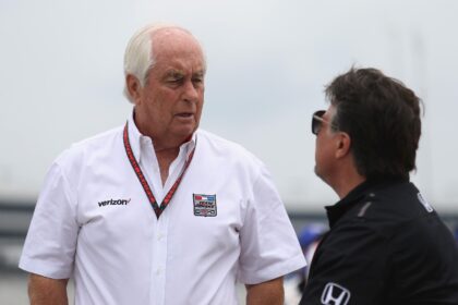 IndyCar team owner Roger Penske, left, talks with rival team owner Michael Andretti, right