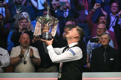 Joy of victory: England's Kyren Wilson poses with the trophy after defeating Wales's Jak J