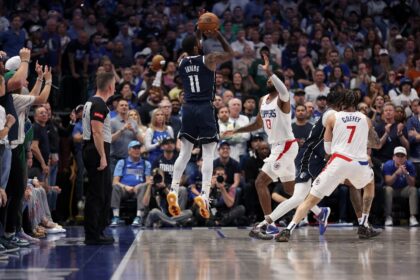 Kyrie Irving of the Dallas Mavericks takes a three-point shot over Paul George in the Mave