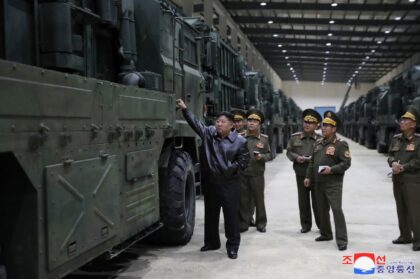 North Korean leader Kim Jong Un (L) inspects missile launcher vehicles at an undisclosed l