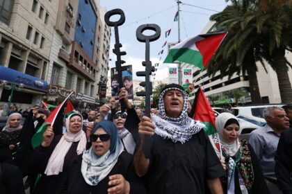 Palestinian protesters hold symbolic keys during a rally in the northern West Bank city of